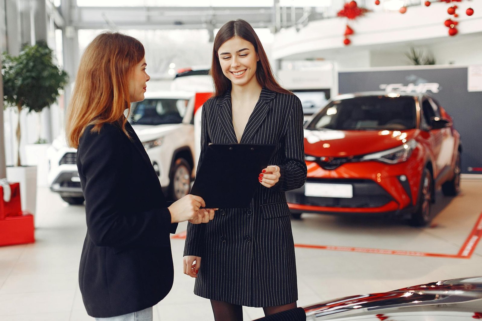 Vendedor de stand de automóveis a fechar contrato com cliente — momento de conversão de lead em venda real